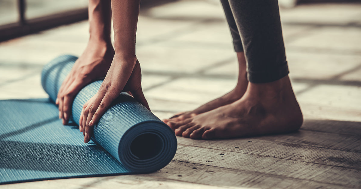 woman rolling up yoga mat